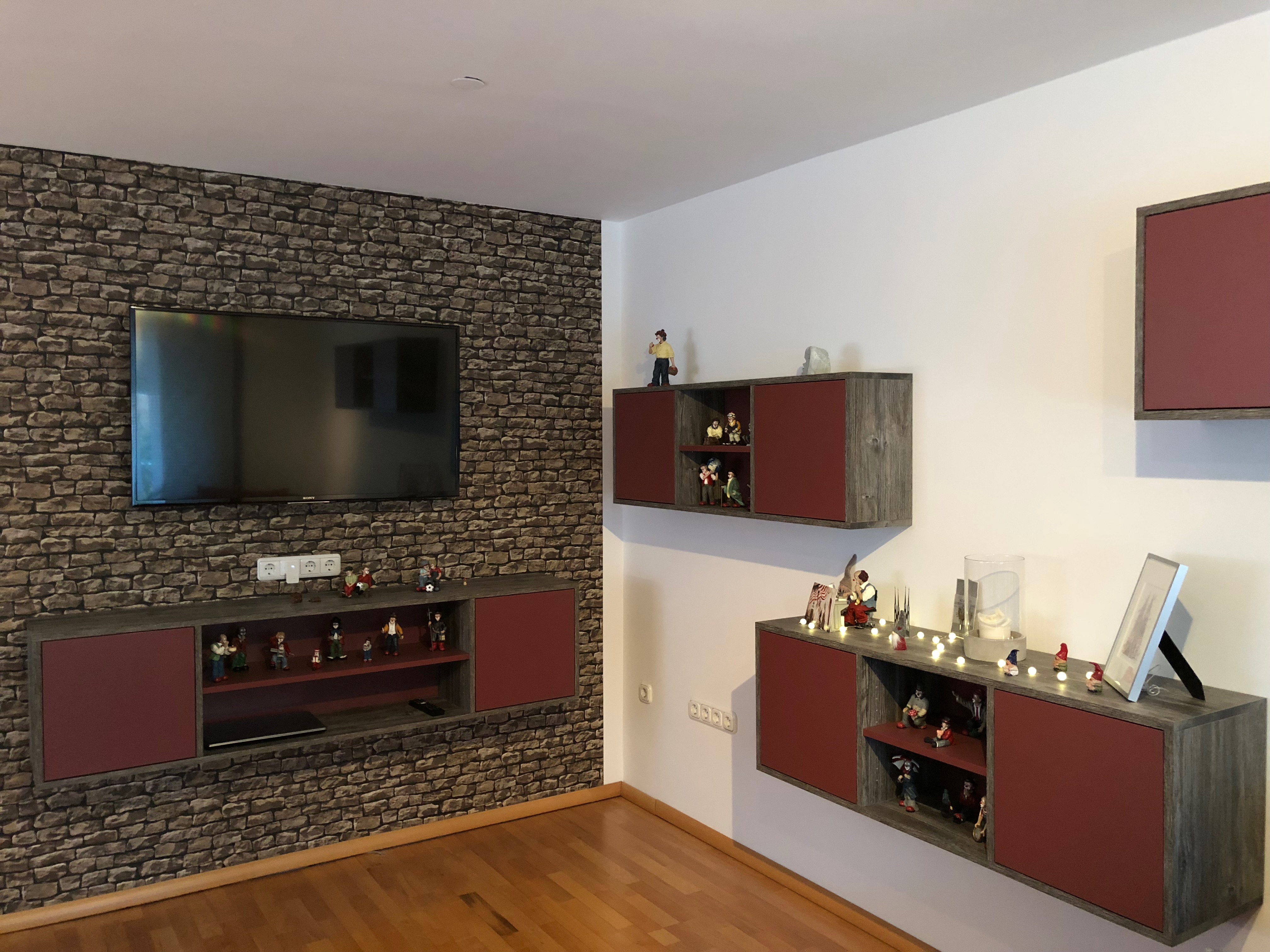 Wohnzimmerausstattung Hängeschränke Betonoptik und Bordeauxrot